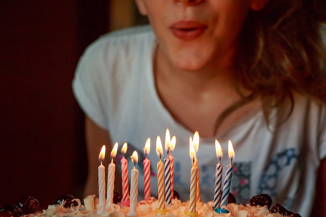 child blowing candles out on birthday cake